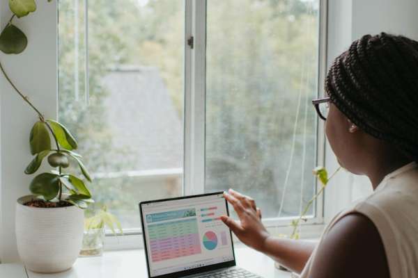 a woman sitting at a table using a laptop computer